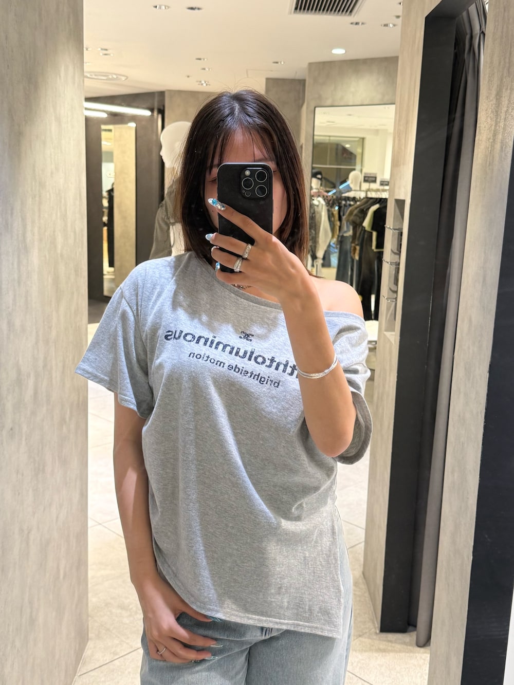 グレー系のTシャツ/カットソー、ブルー系のデニムパンツ、ブラック系のスニーカーを着用したレディースの春コーディネートの4枚目の写真