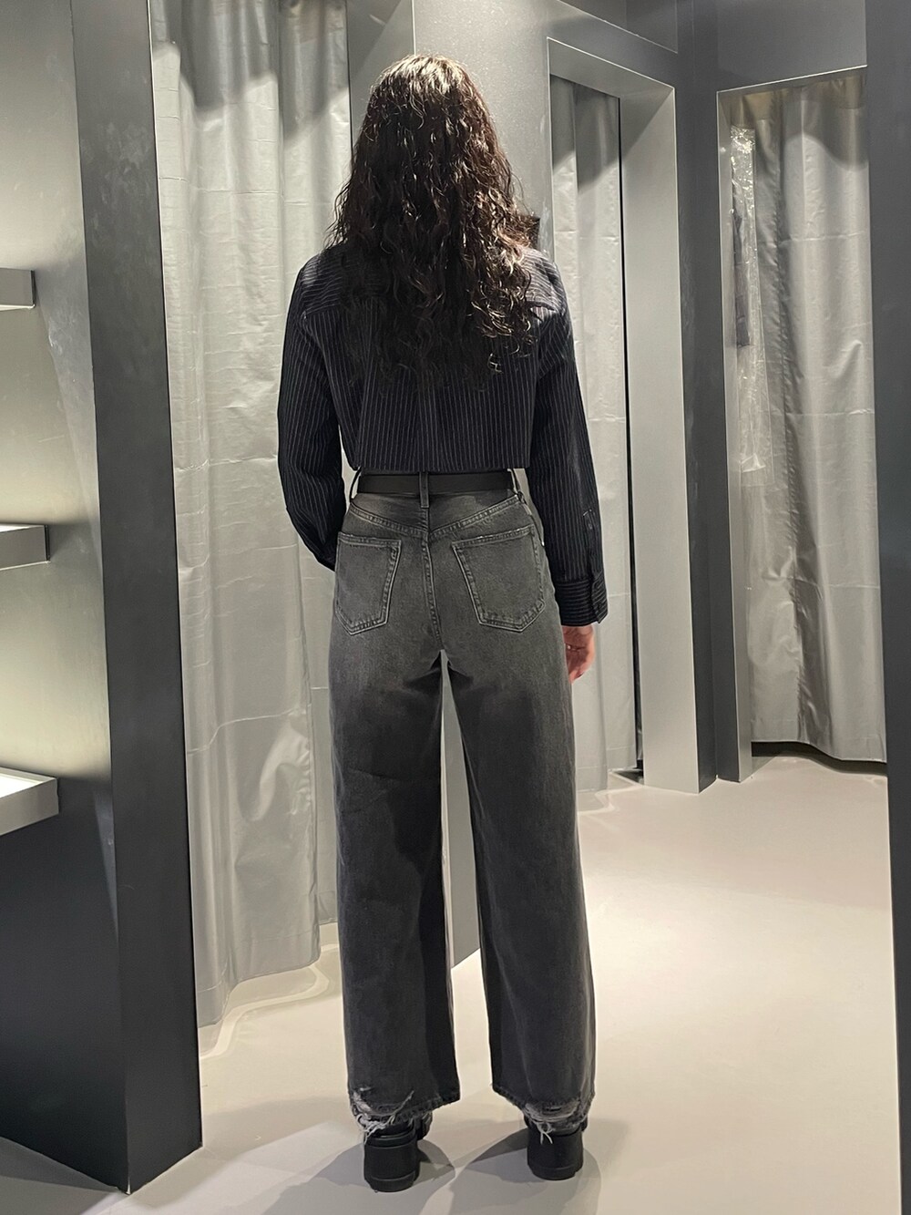 ブルー系のシャツ/ブラウス、グレー系のデニムパンツ、ブラック系のブーツを着用したレディースの秋コーディネートの3枚目の写真