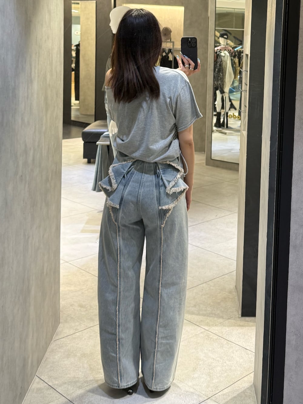 グレー系のTシャツ/カットソー、ブルー系のデニムパンツ、ブラック系のスニーカーを着用したレディースの春コーディネートの3枚目の写真