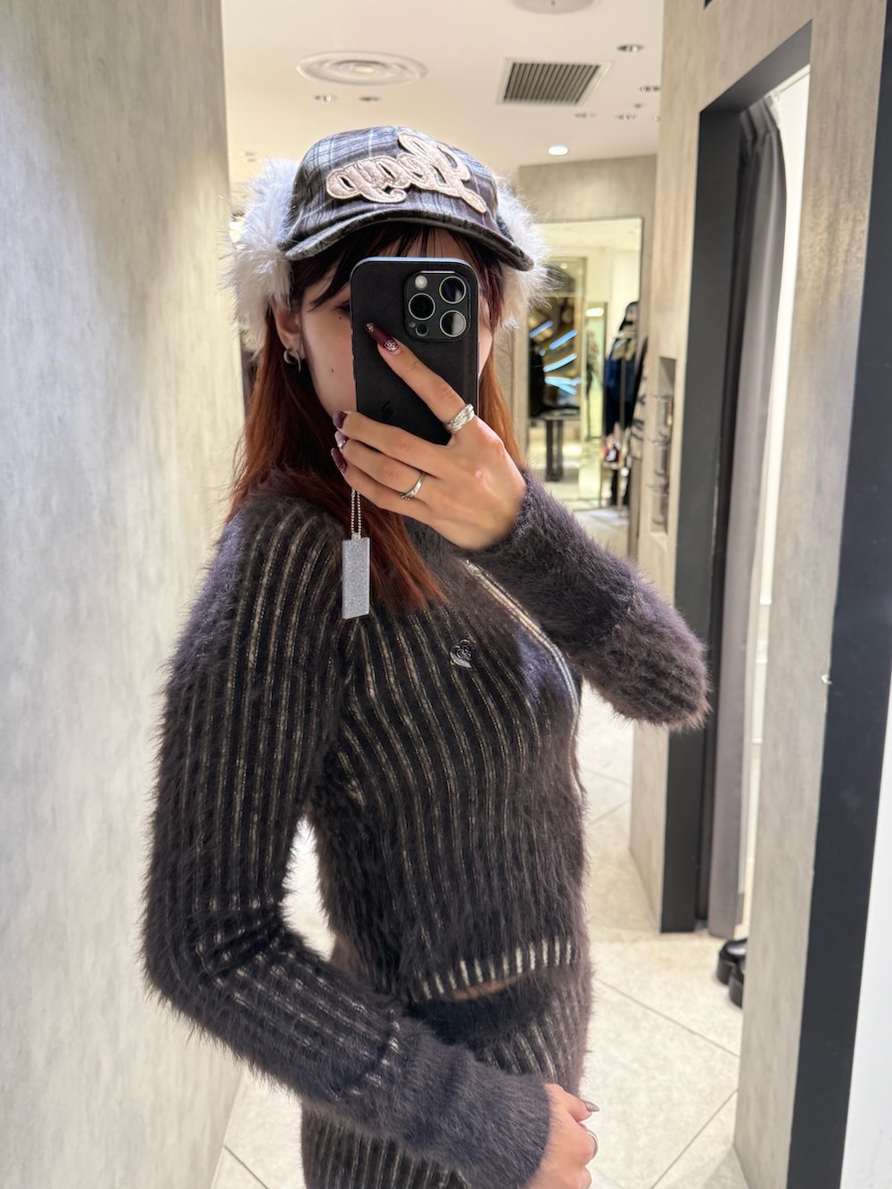 ブラウン系のニット/セーター、ブラウン系のスカート、ブラック系のブーツを着用したレディースの秋コーディネートの5枚目の写真