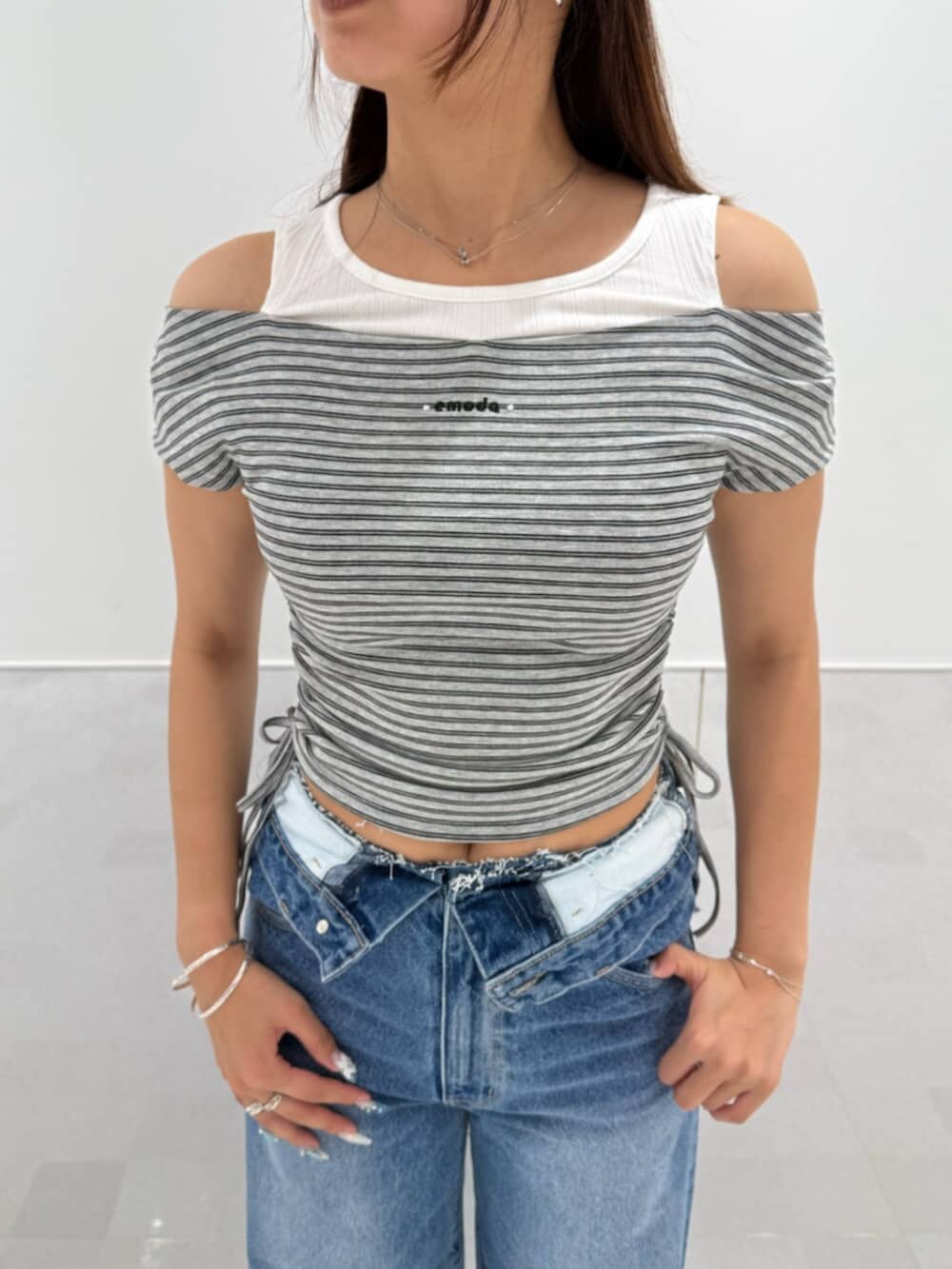 ブラック系のブーツ、グレー系のTシャツ/カットソー、ブルー系のデニムパンツを着用したレディースの夏コーディネートの4枚目の写真