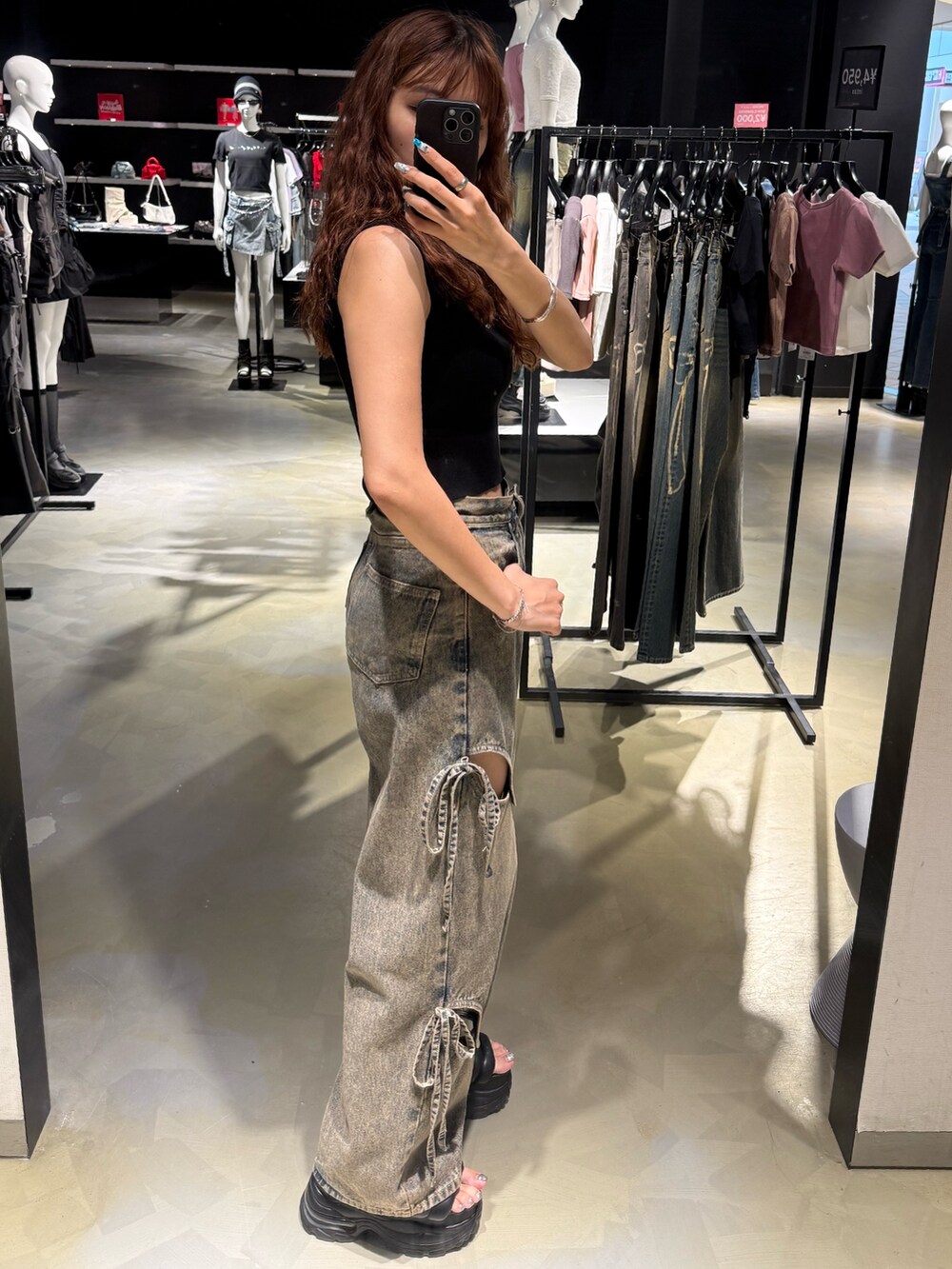 ブラック系のTシャツ/カットソー、ブルー系のデニムパンツ、ブラック系のサンダルを着用したレディースの夏コーディネートの2枚目の写真