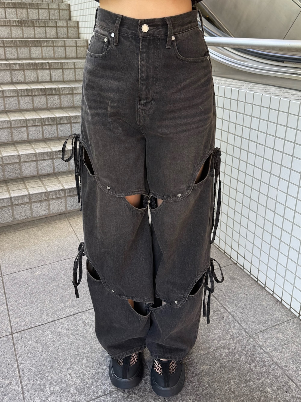 ブラウン系のタンクトップ、ブラック系のハンドバッグ、ブラック系のデニムパンツを着用したレディースの夏コーディネートの7枚目の写真