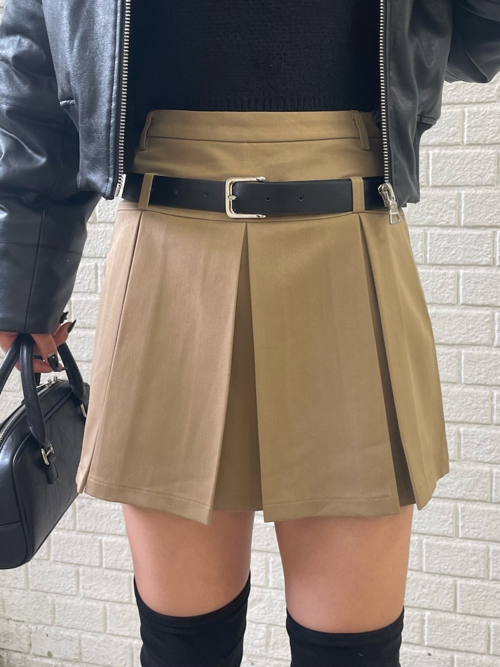 ブラック系のニット/セーター、ブラック系のブルゾン、ベージュ系のスカートを着用したレディースの秋コーディネートの9枚目の写真