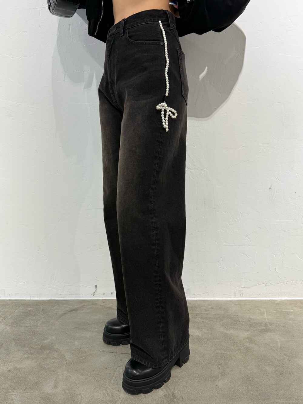 ブラック系のTシャツ/カットソー、ブラック系のデニムパンツ、ブラック系のショルダーバッグを着用したレディースの秋コーディネートの6枚目の写真