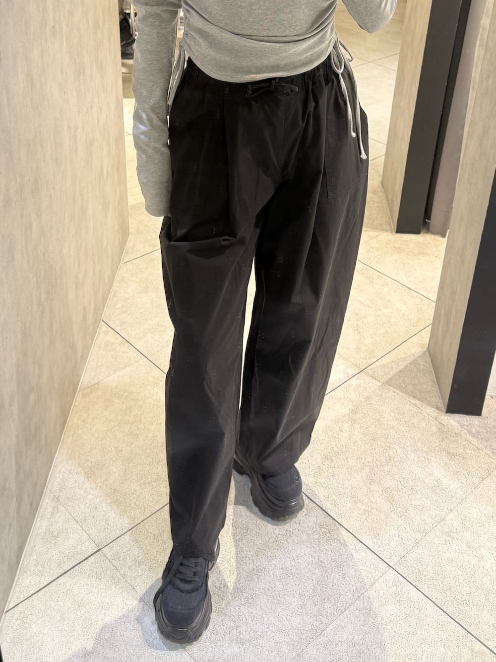 グレー系のTシャツ/カットソー、ブラック系のその他パンツ、ブラック系のスニーカーを着用したレディースの春コーディネートの5枚目の写真