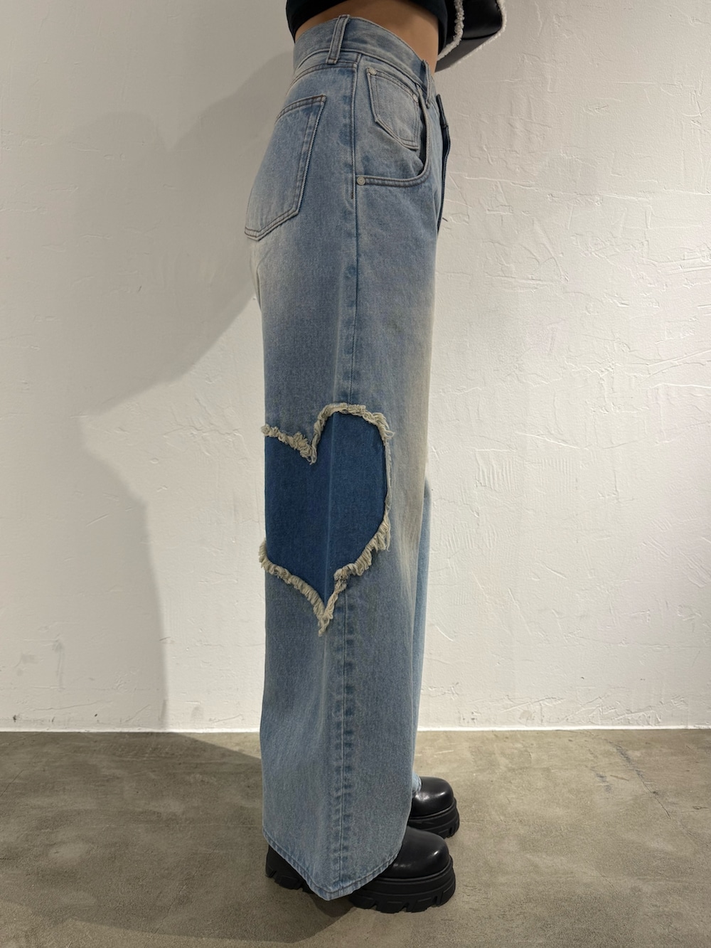 ホワイト系のニット/セーター、ブルー系のデニムパンツ、ブラック系のハンドバッグを着用したレディースの秋コーディネートの7枚目の写真