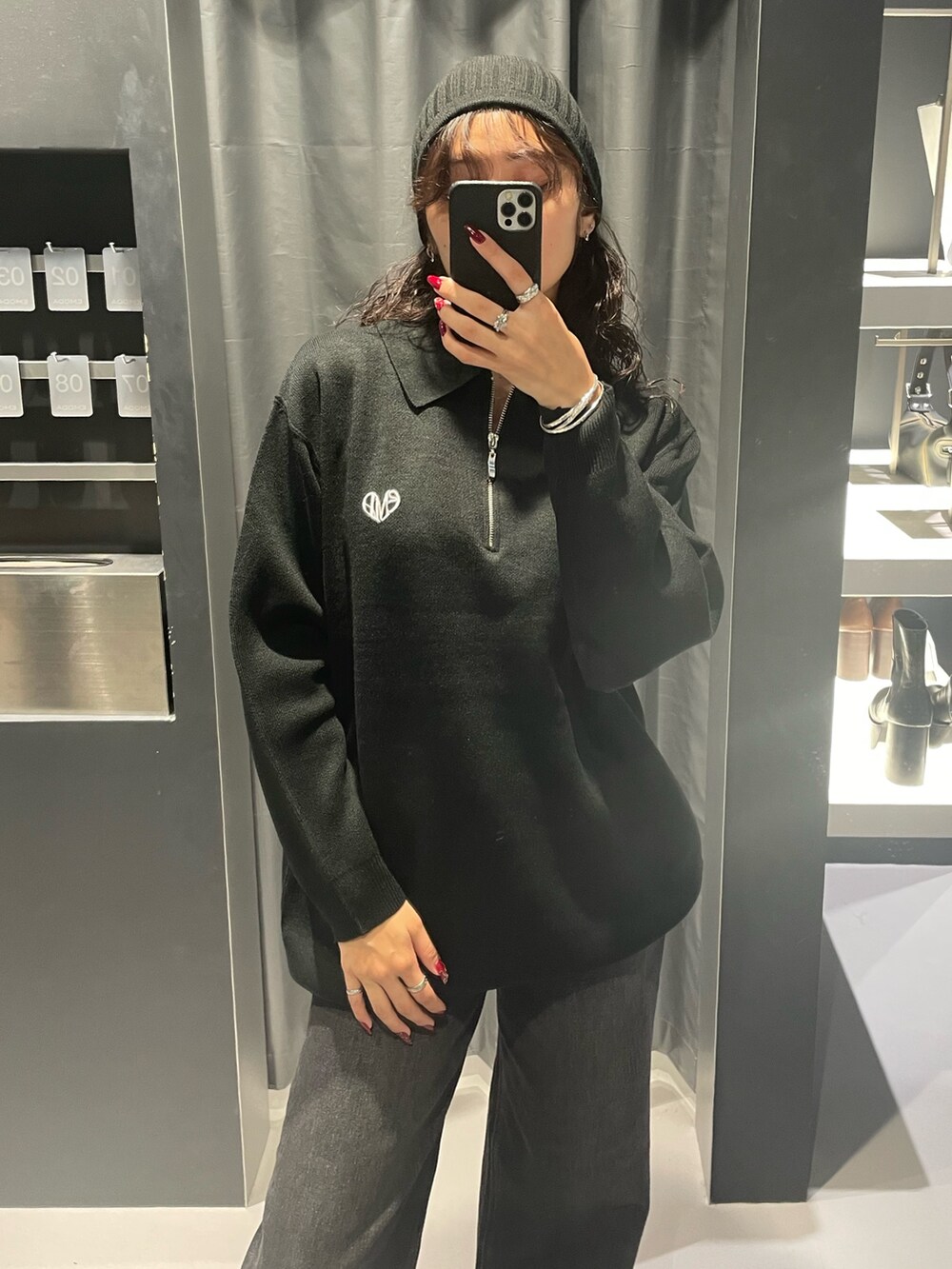 ブラック系のワンピース、ブラック系のデニムパンツ、ブラック系のブーツを着用したレディースの秋コーディネートの4枚目の写真