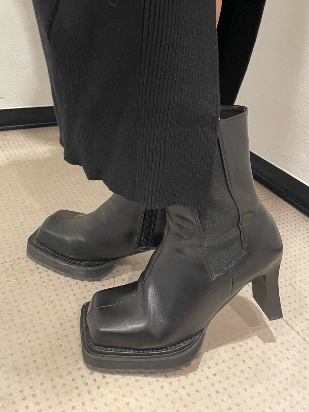 ブラック系のワンピース、ブラック系のハンドバッグ、ブラック系のブーツを着用したレディースの秋コーディネートの9枚目の写真