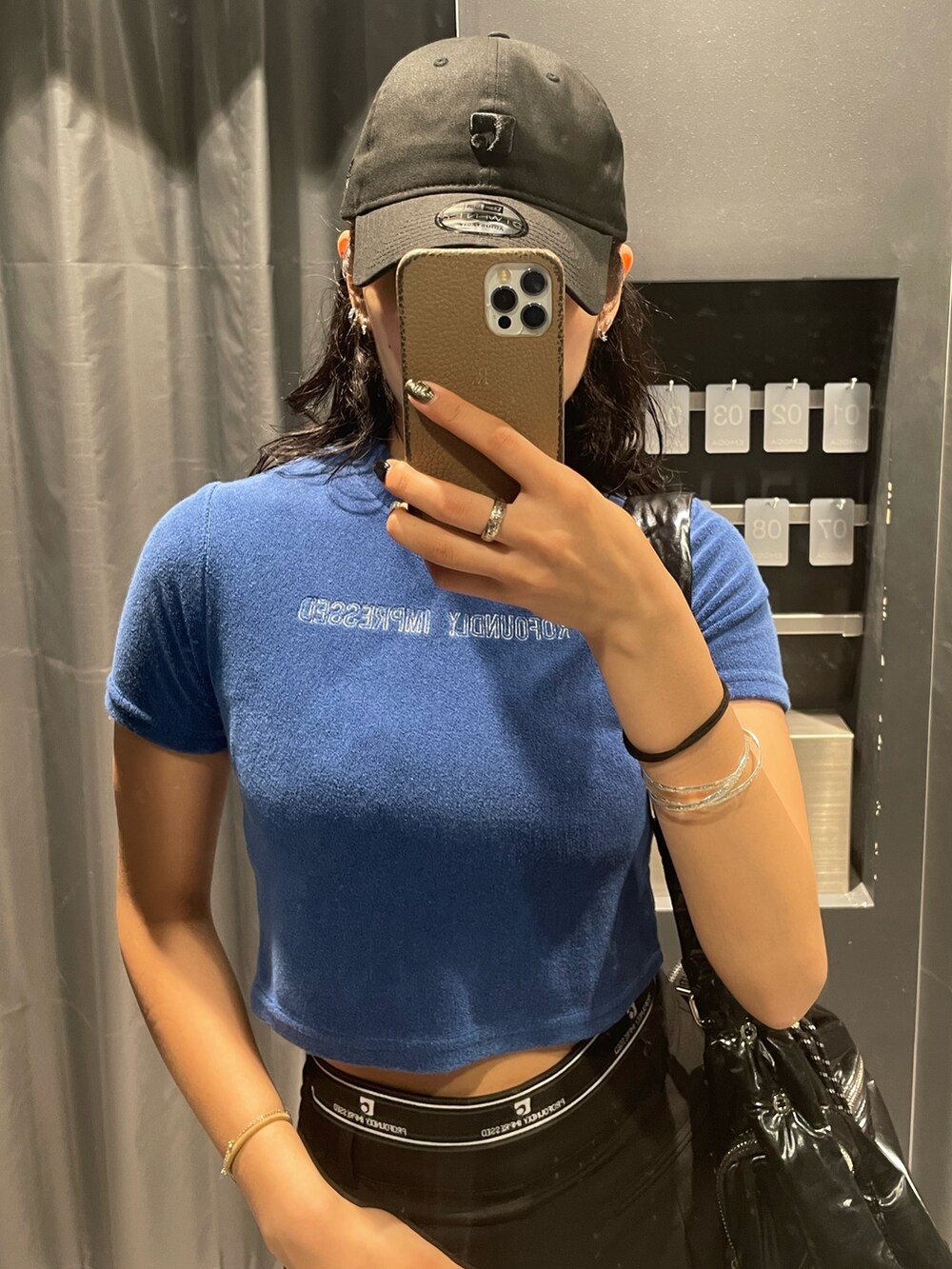 ブルー系のTシャツ/カットソー、ブラック系のハンドバッグ、ブラック系のスカートを着用したレディースの夏コーディネートの4枚目の写真