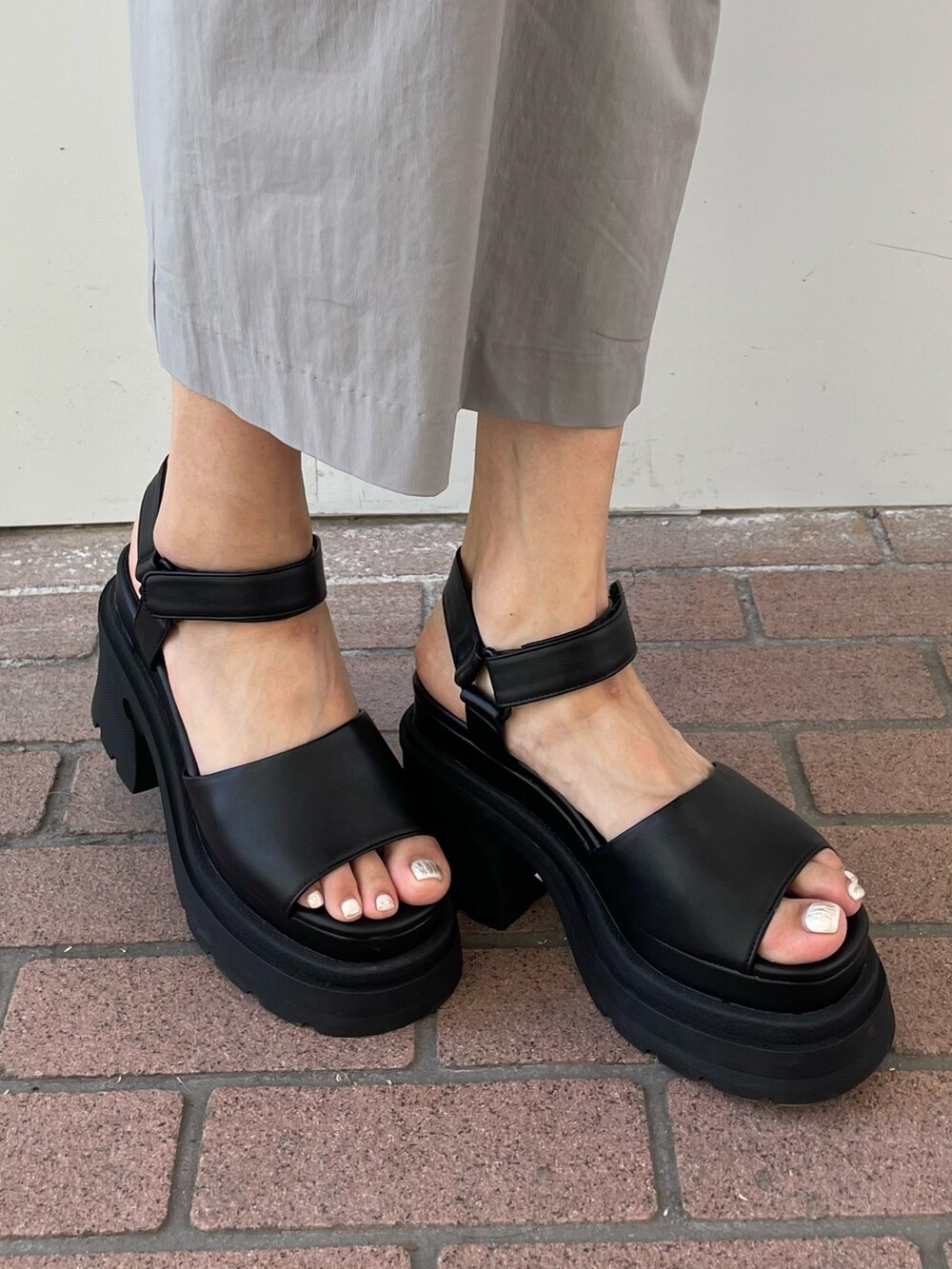 グレー系のワンピース、ブラック系のタンクトップ、ブラック系のサンダルを着用したレディースの夏コーディネートの5枚目の写真