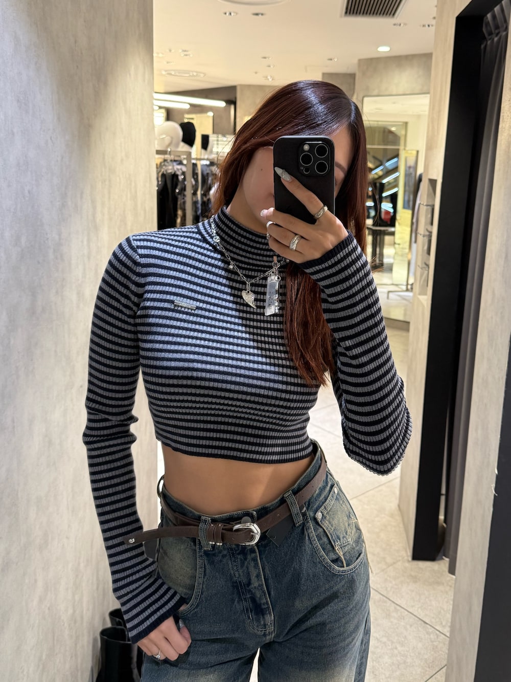 ブルー系のニット/セーター、ブルー系のデニムパンツ、ブラック系のブーツを着用したレディースの冬コーディネートの4枚目の写真