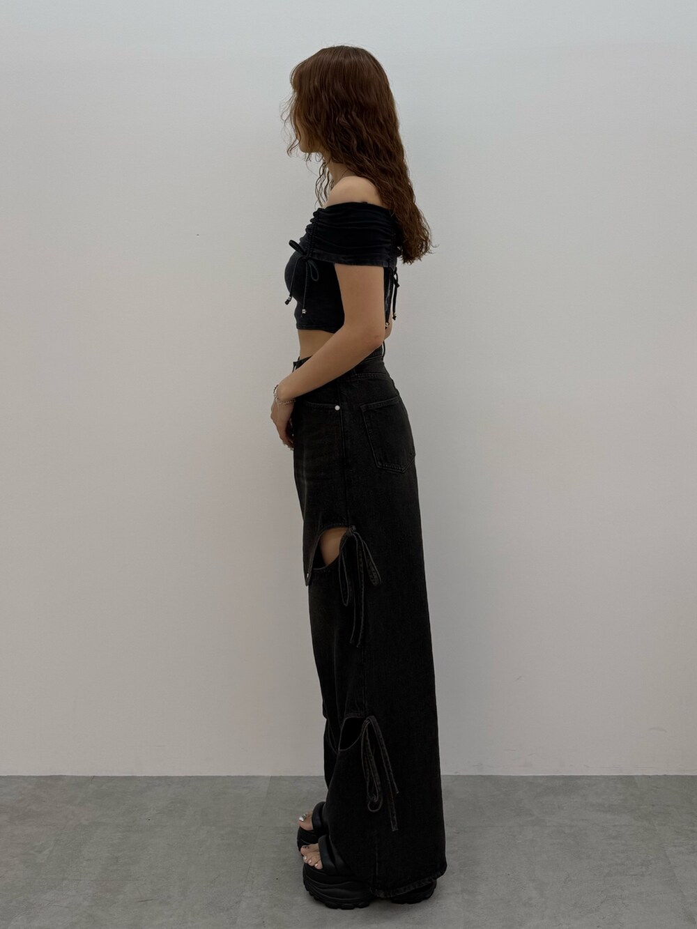 ブラック系のTシャツ/カットソー、ブラック系のデニムパンツ、ブラック系のサンダルを着用したレディースの夏コーディネートの2枚目の写真