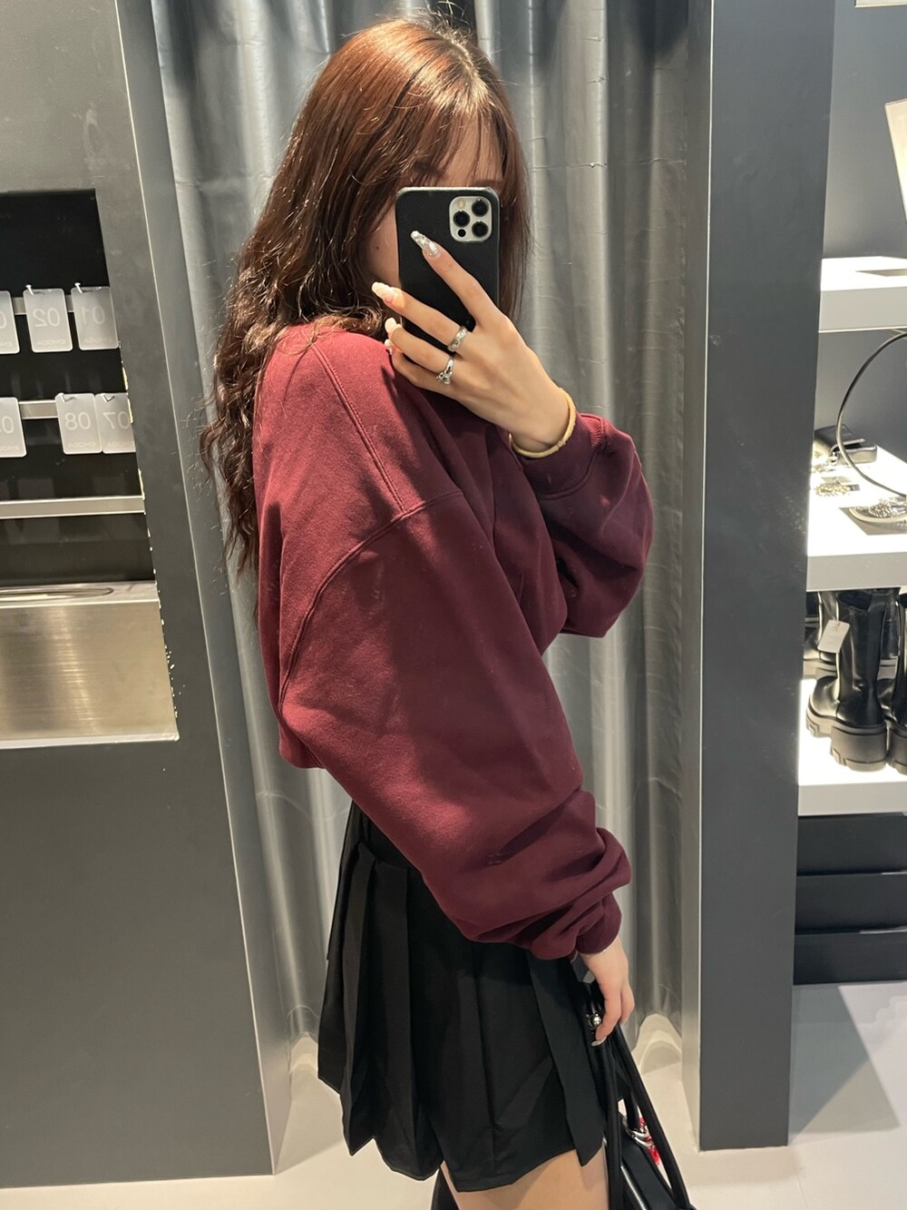 レッド系のTシャツ/カットソー、ブラック系のブルゾン、ブラック系のスカートを着用したレディースの冬コーディネートの7枚目の写真