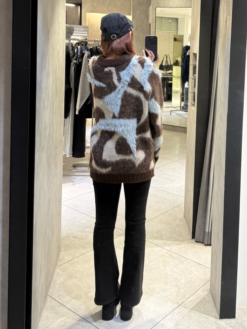 ブラウン系のニット/セーター、ブラック系のデニムパンツ、ブラック系のブーツを着用したレディースの秋コーディネートの3枚目の写真