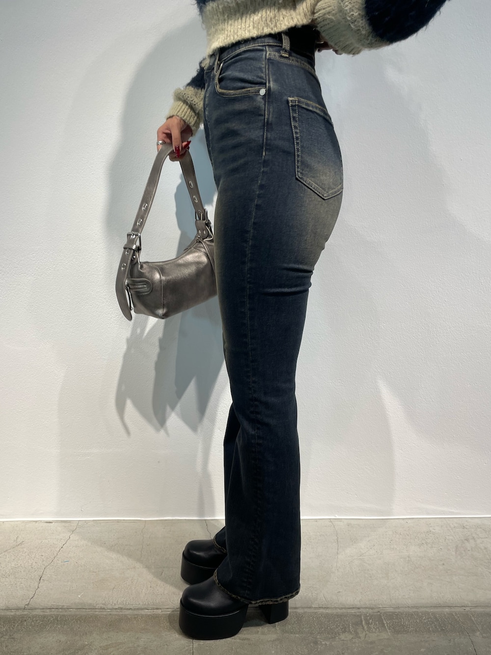 ホワイト系のニット/セーター、ブルー系のデニムパンツ、ブラウン系のショルダーバッグを着用したレディースの秋コーディネートの8枚目の写真