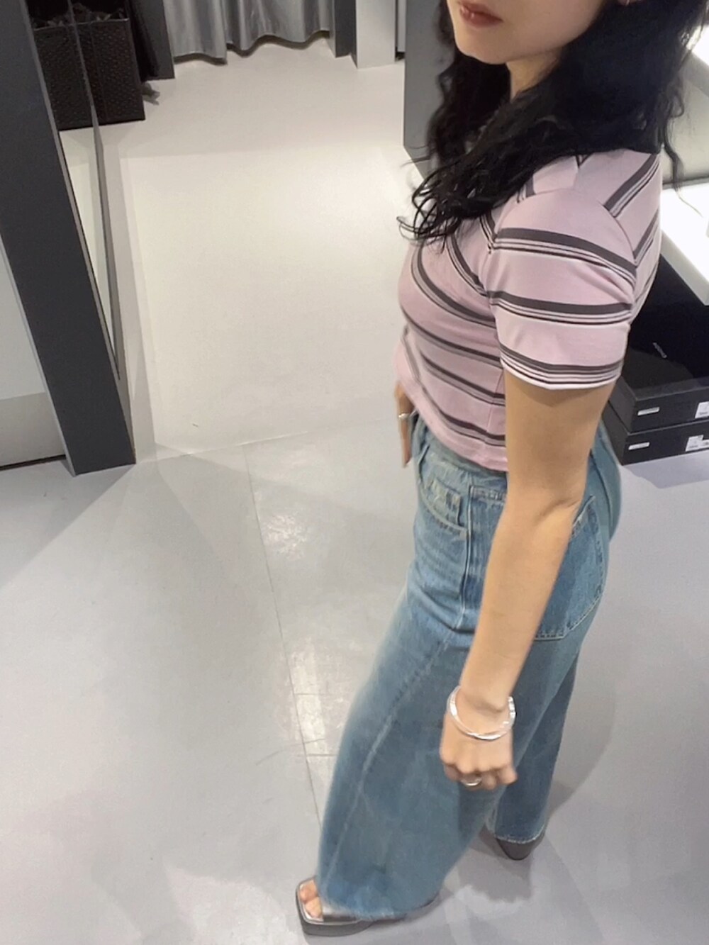 ピンク系のTシャツ/カットソー、ブルー系のデニムパンツ、シルバー系のサンダルを着用したレディースの春コーディネートの2枚目の写真