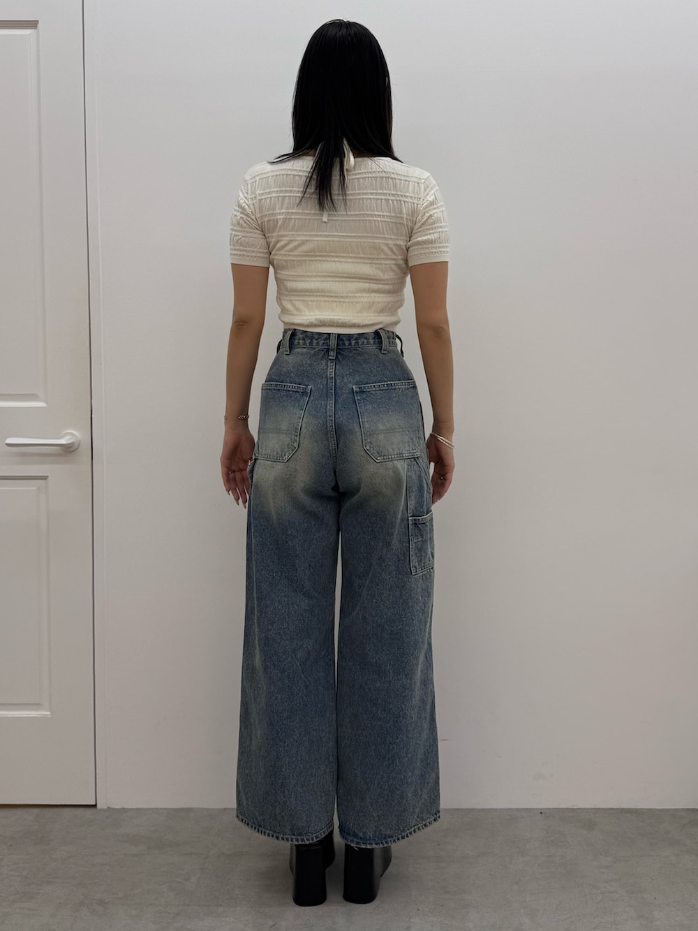 ブラック系のサンダル、ブルー系のデニムパンツ、ホワイト系のニット/セーターを着用したレディースの春コーディネートの3枚目の写真