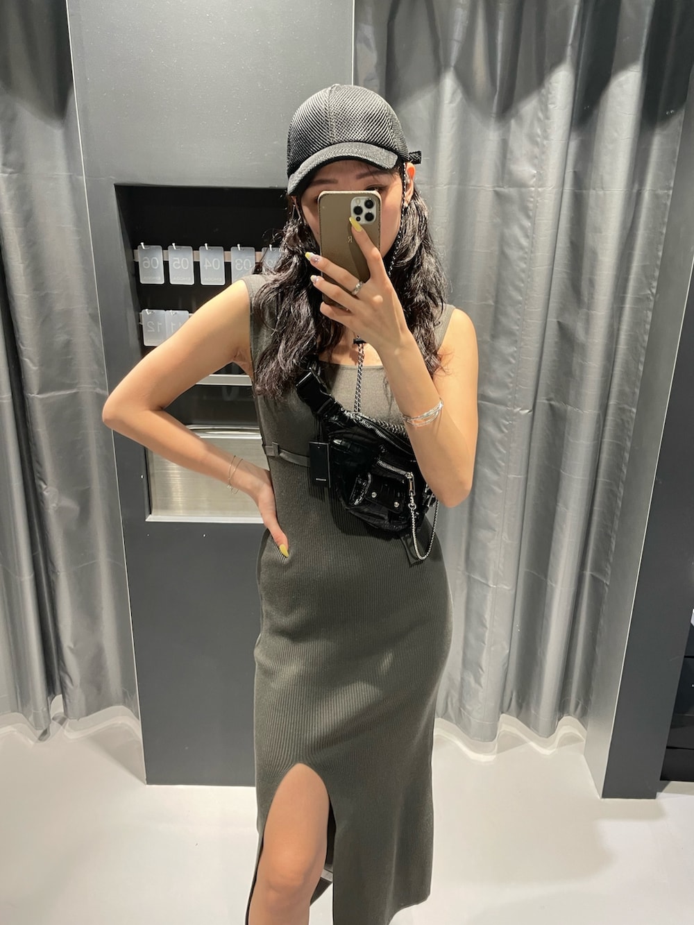 ブラック系のハンドバッグ、グレー系のワンピース、ブラック系のサンダルを着用したレディースの春コーディネートの4枚目の写真