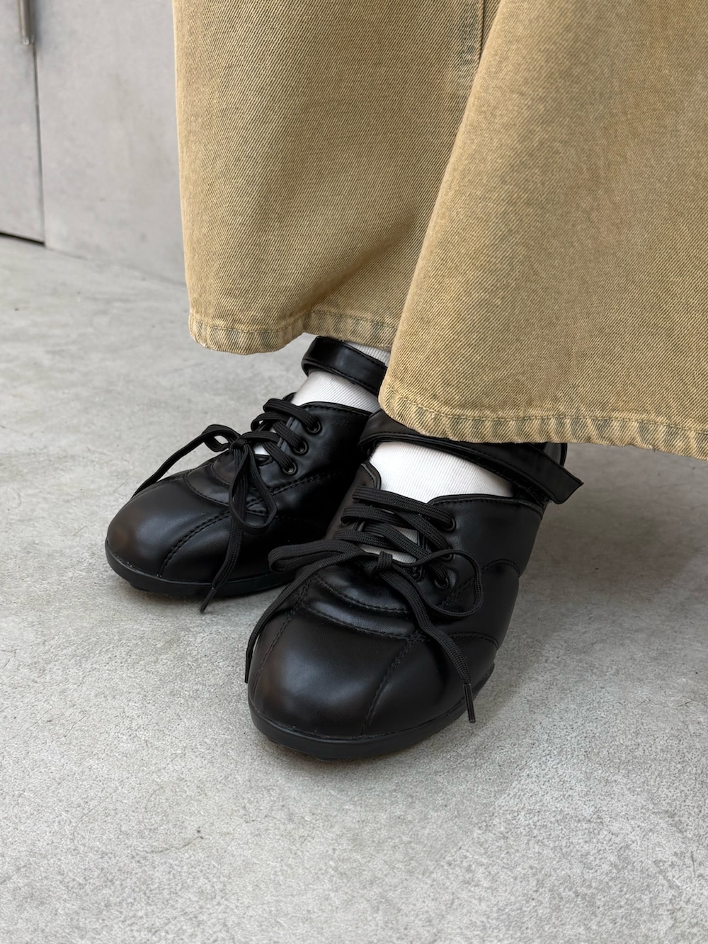 ブラック系のシャツ/ブラウス、ベージュ系のデニムパンツ、ブラック系のスニーカーを着用したレディースの冬コーディネートの5枚目の写真