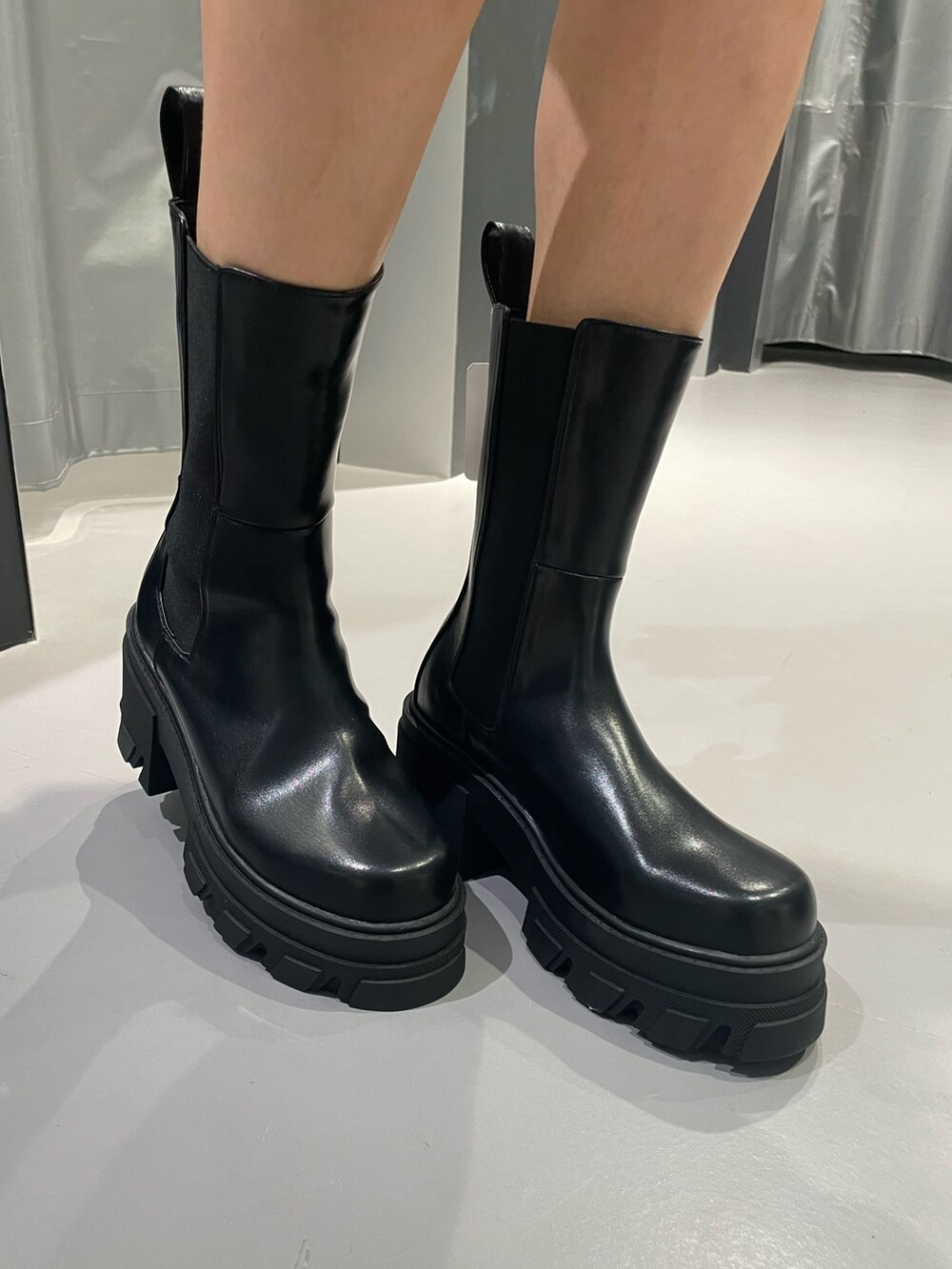 ブラック系のパーカー、ブルー系のデニムパンツ、ブラック系のブーツを着用したレディースの秋コーディネートの8枚目の写真