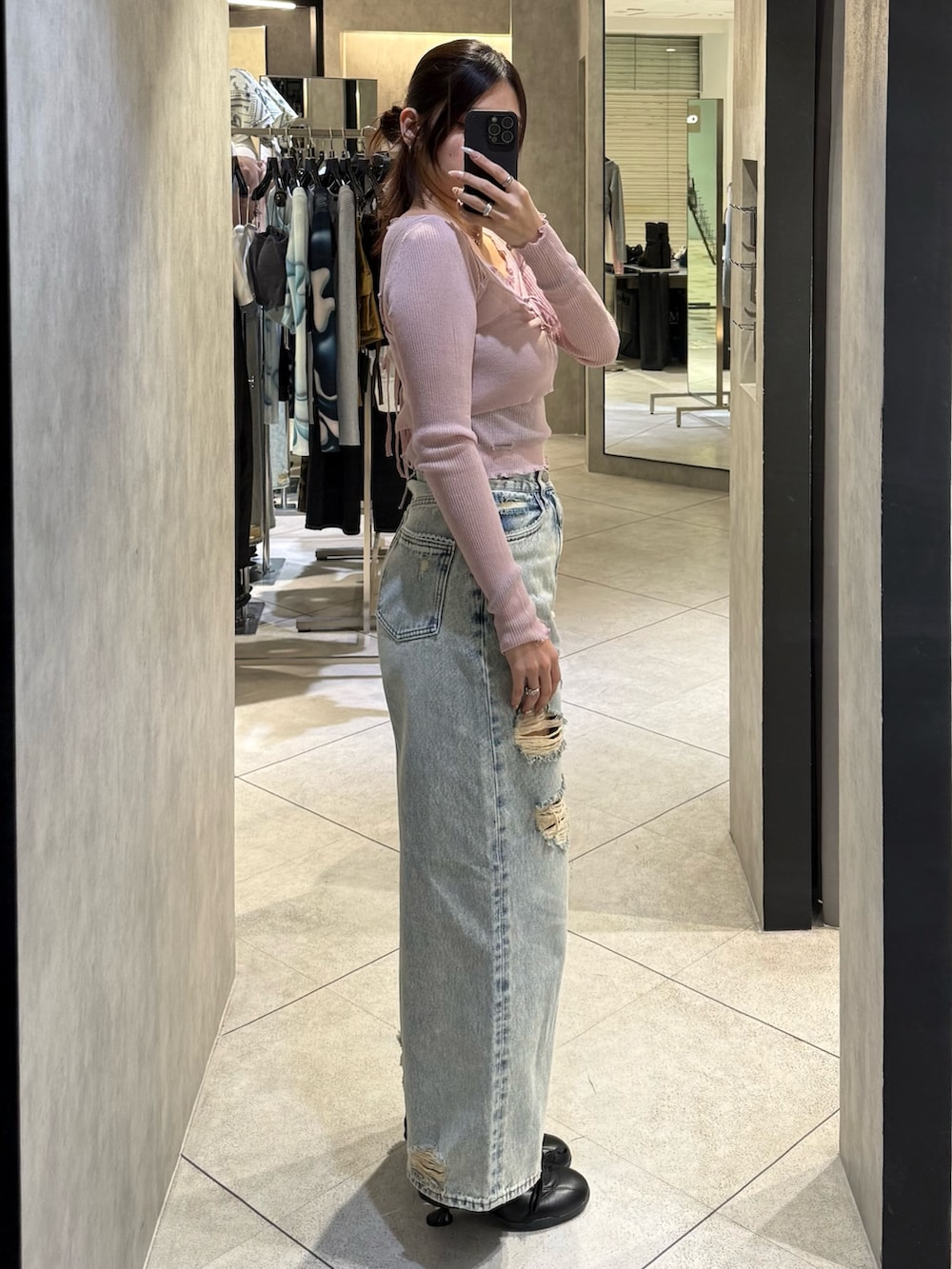 ブルー系のデニムパンツ、ブラック系のスニーカー、ピンク系のニット/セーターを着用したレディースの春コーディネートの2枚目の写真