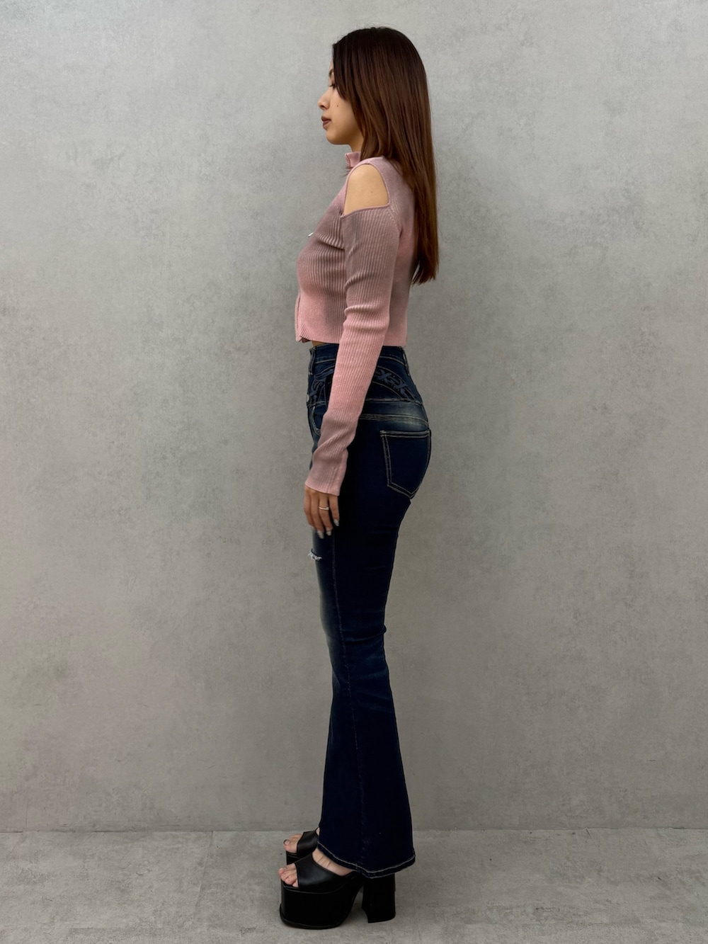 ピンク系のニット/セーター、ブルー系のデニムパンツ、ブラック系のサンダルを着用したレディースの冬コーディネートの2枚目の写真