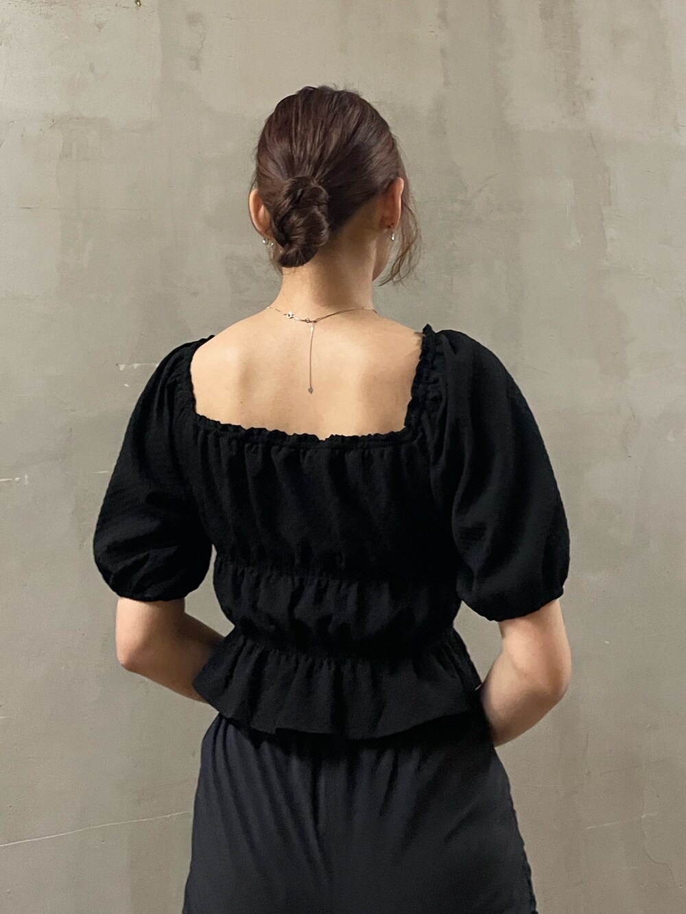 ブラック系のTシャツ/カットソー、ブラック系のスカート、ブラック系のサンダルを着用したレディースの春コーディネートの6枚目の写真