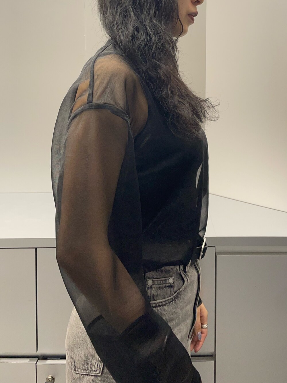 ブラック系のタンクトップ、ブラック系のTシャツ/カットソー、グレー系のデニムパンツを着用したレディースの春コーディネートの5枚目の写真