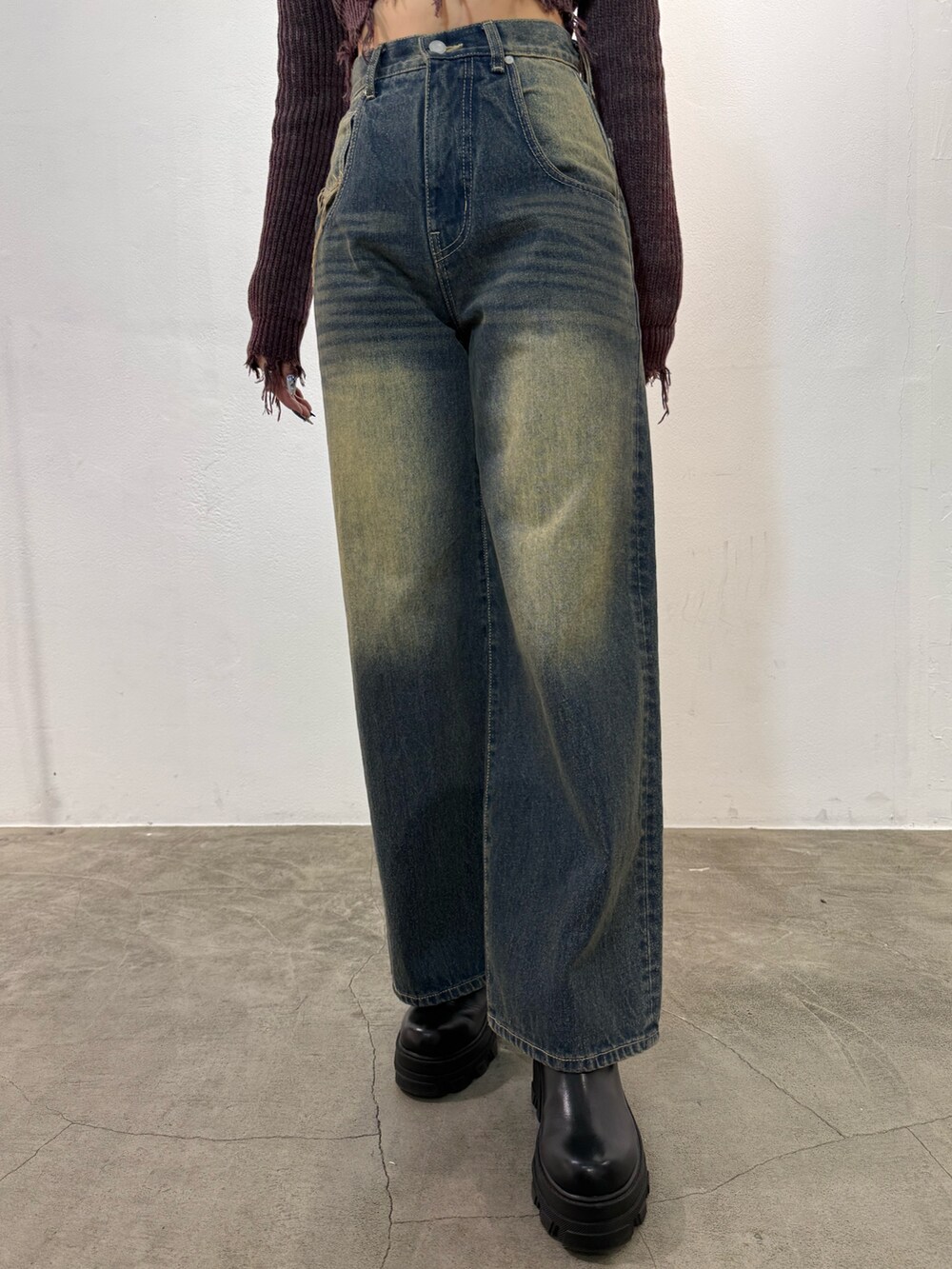 レッド系のニット/セーター、ブルー系のデニムパンツ、ブラック系のブーツを着用したレディースの冬コーディネートの5枚目の写真