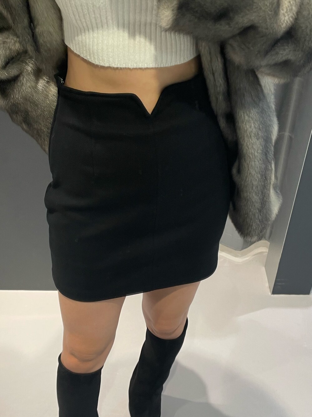 ホワイト系のニット/セーター、グレー系のその他アウター、ブラック系のスカートを着用したレディースの冬コーディネートの7枚目の写真