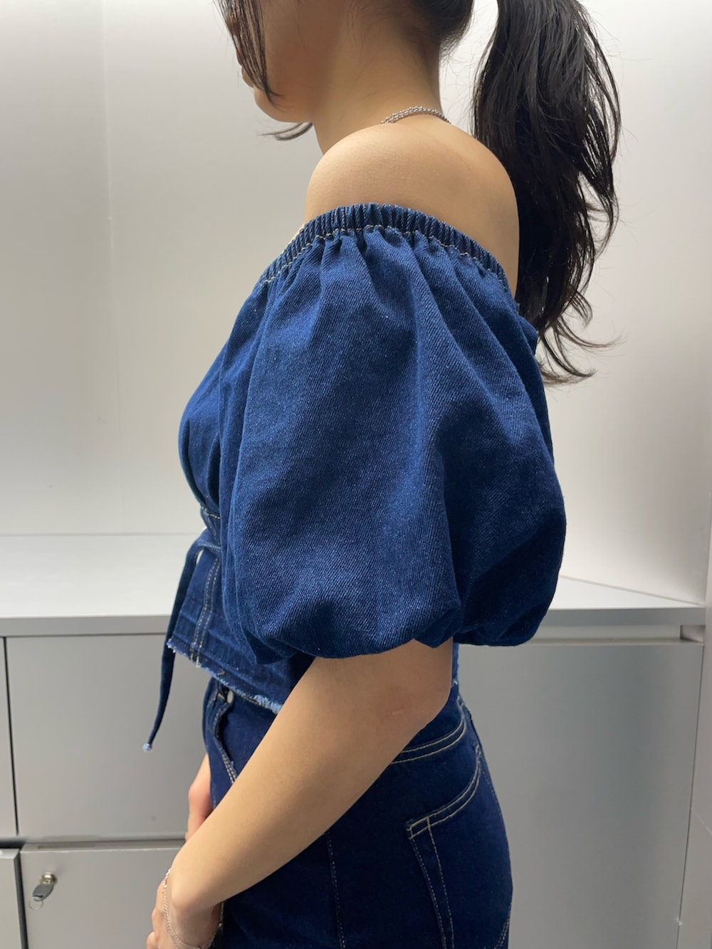 ブルー系のシャツ/ブラウス、ブルー系のスカート、ブラック系のハンドバッグを着用したレディースの春コーディネートの5枚目の写真