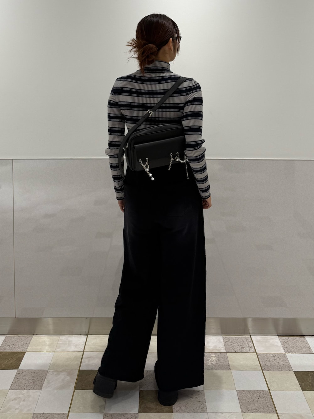 グレー系のニット/セーター、ブラック系のスウェットパンツ、ブラック系のブーツを着用したレディースの秋コーディネートの3枚目の写真