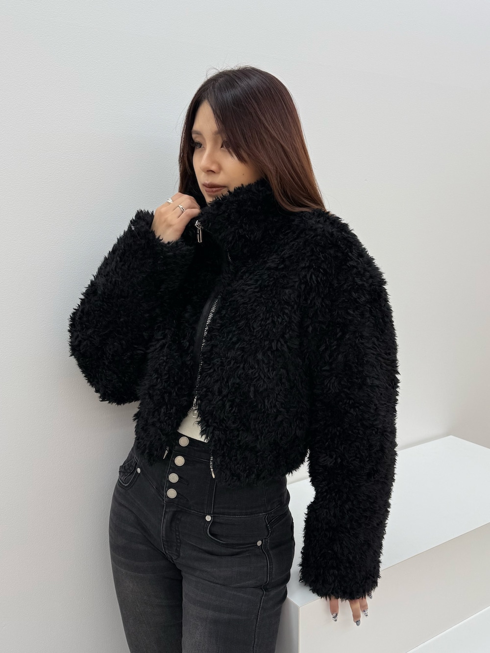 ブラック系のブルゾン、ブラック系のデニムパンツ、ブラック系のブーツを着用したレディースの冬コーディネートの4枚目の写真