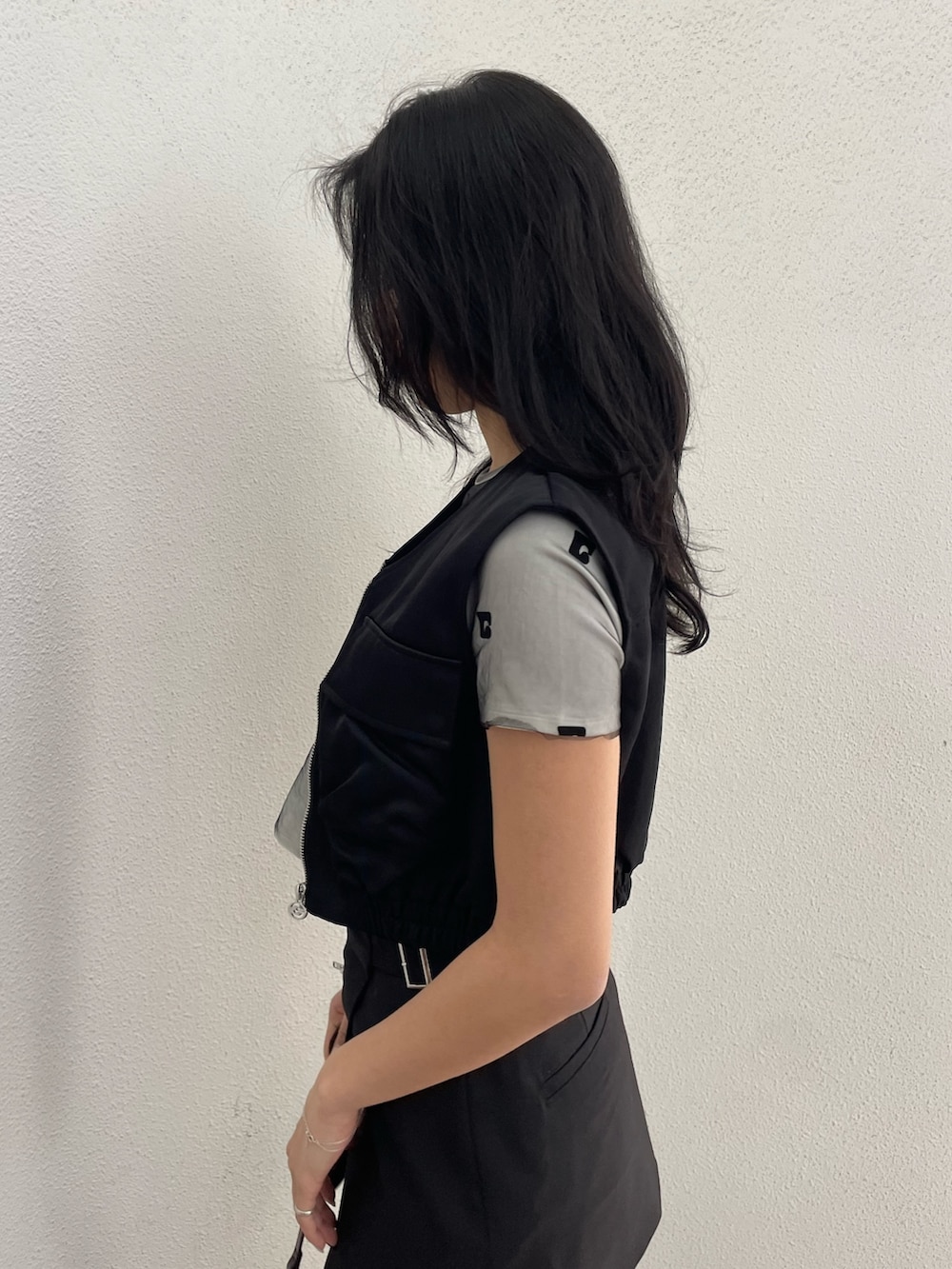 ホワイト系のTシャツ/カットソー、ブラック系のベスト、ブラック系のその他パンツを着用したレディースの春コーディネートの5枚目の写真