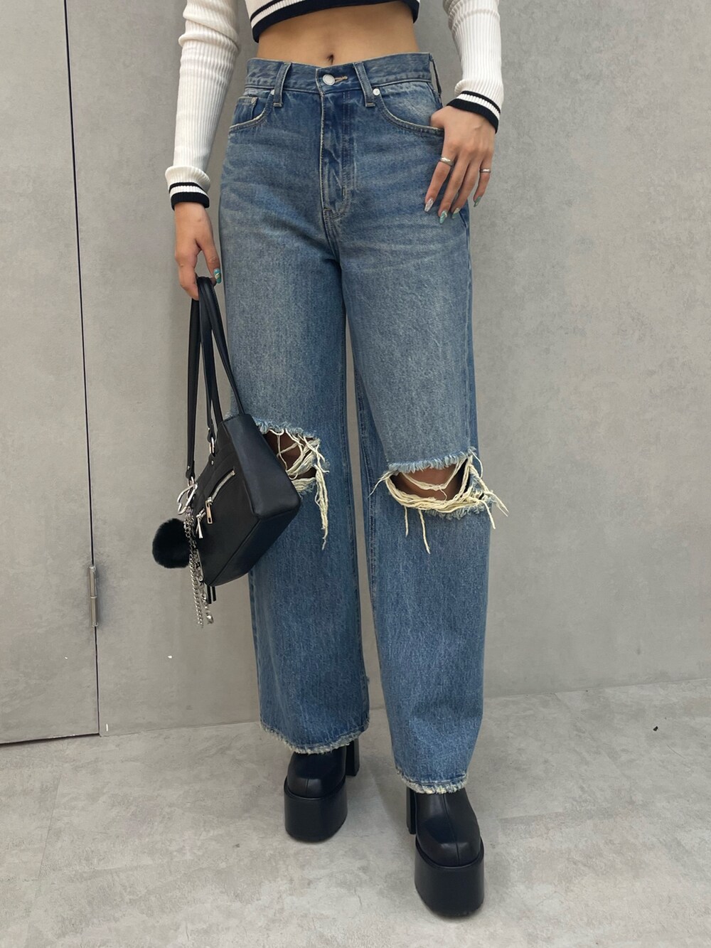 ホワイト系のニット/セーター、ブルー系のデニムパンツ、ブラック系のショルダーバッグを着用したレディースの夏コーディネートの7枚目の写真