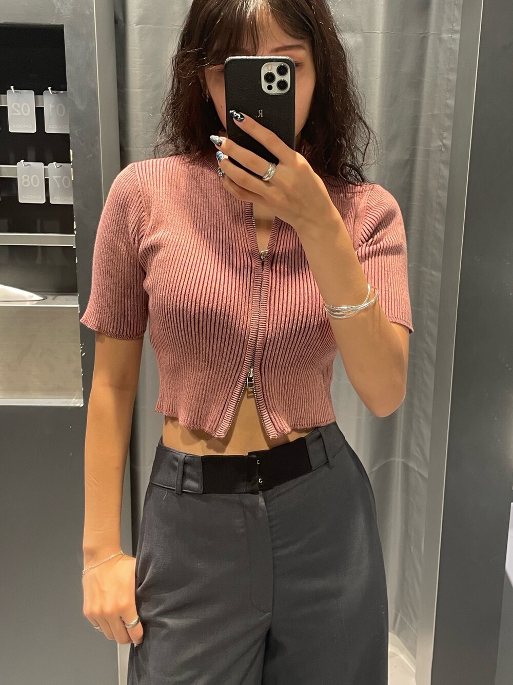 ピンク系のニット/セーター、グレー系のスカート、ブラック系のハンドバッグを着用したレディースの夏コーディネートの4枚目の写真