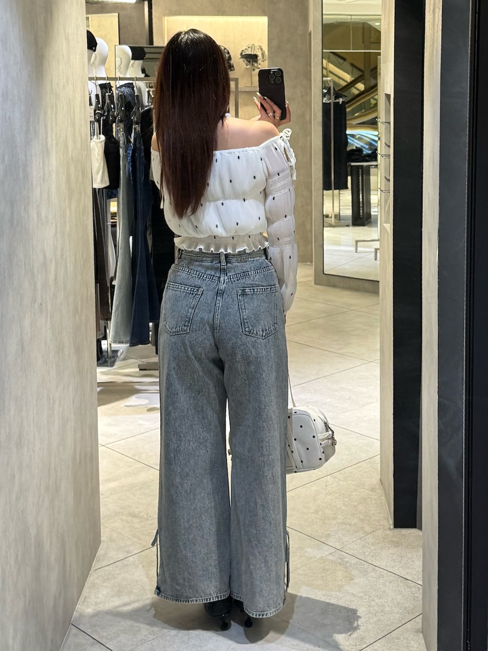 ホワイト系のTシャツ/カットソー、ブルー系のデニムパンツ、ホワイト系のショルダーバッグを着用したレディースの春コーディネートの3枚目の写真