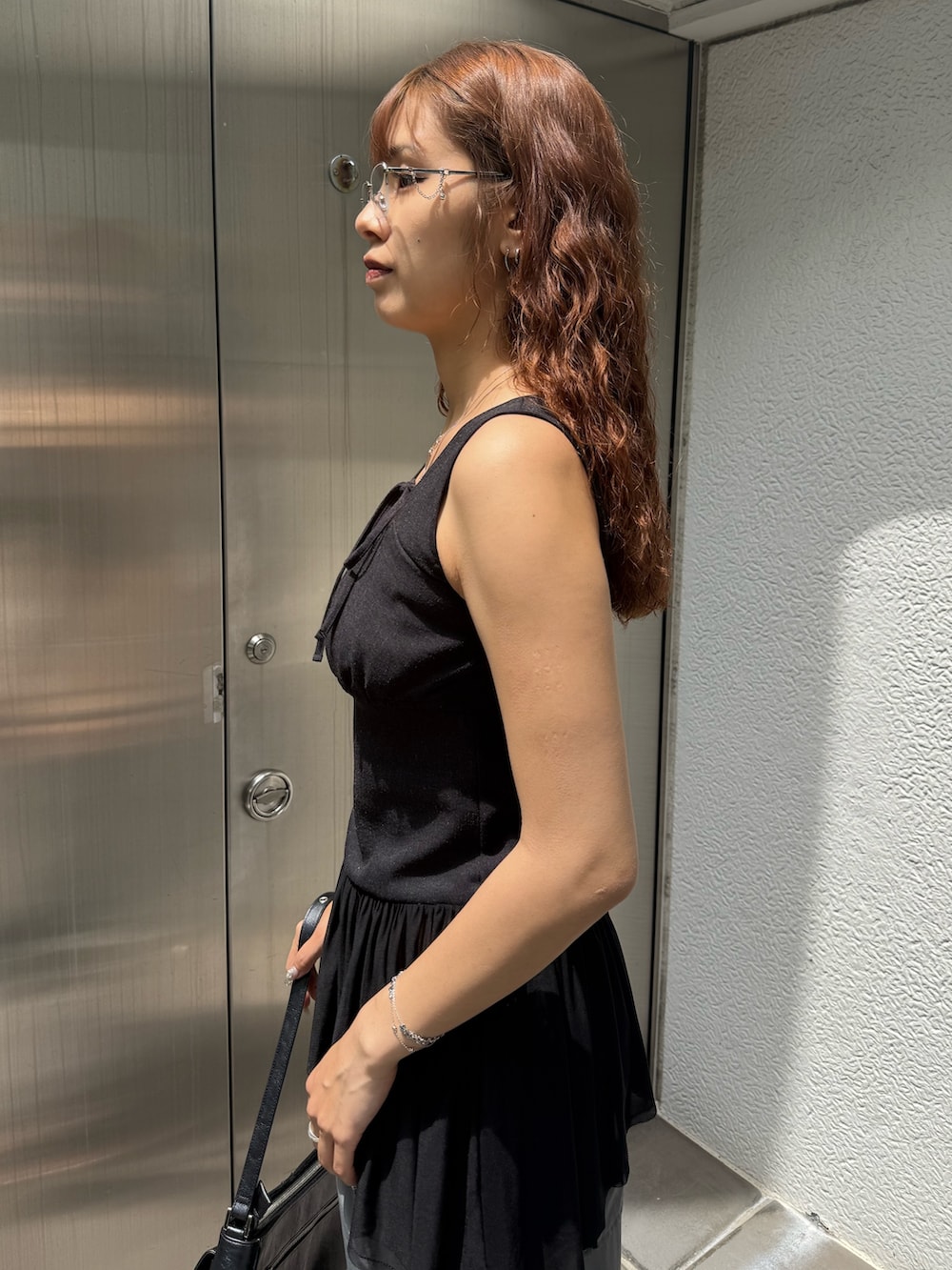 ブラック系のTシャツ/カットソー、ブラック系のハンドバッグ、グレー系のその他パンツを着用したレディースの夏コーディネートの5枚目の写真