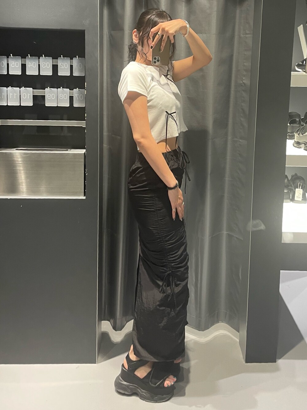 ホワイト系のTシャツ/カットソー、ブラック系のスカート、ブラック系のサンダルを着用したレディースの夏コーディネートの2枚目の写真