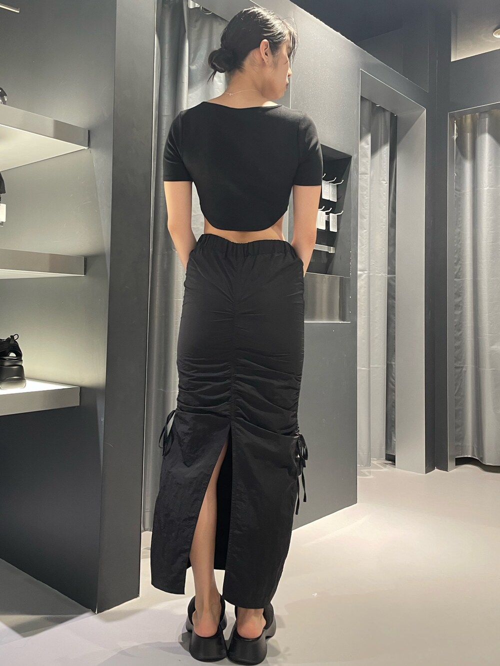 ブラック系のTシャツ/カットソー、ブラック系のスカート、ブラック系のサンダルを着用したレディースの夏コーディネートの3枚目の写真