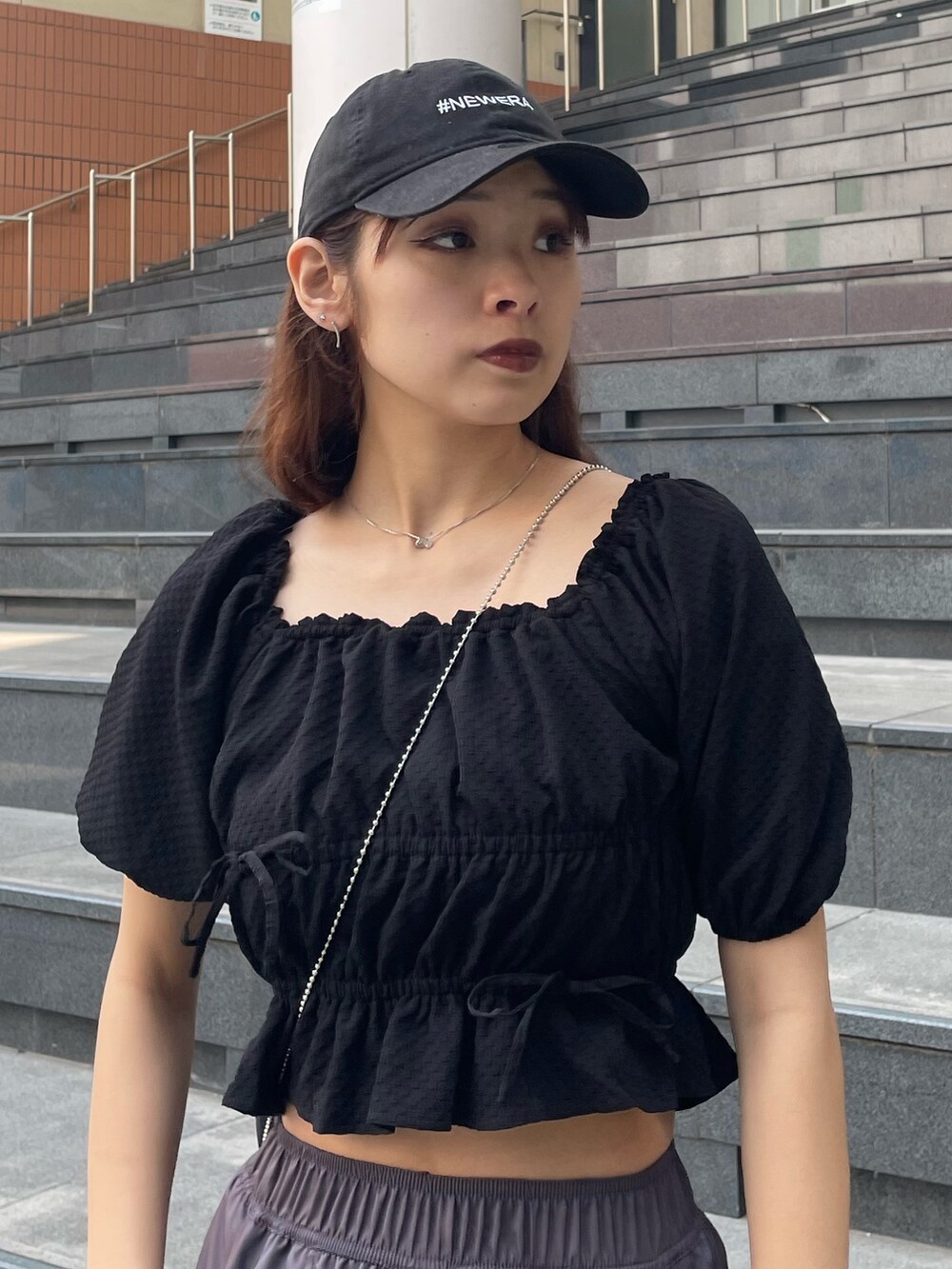 ブラック系のハンドバッグ、ブラック系のTシャツ/カットソー、ブラウン系のその他パンツを着用したレディースの春コーディネートの4枚目の写真