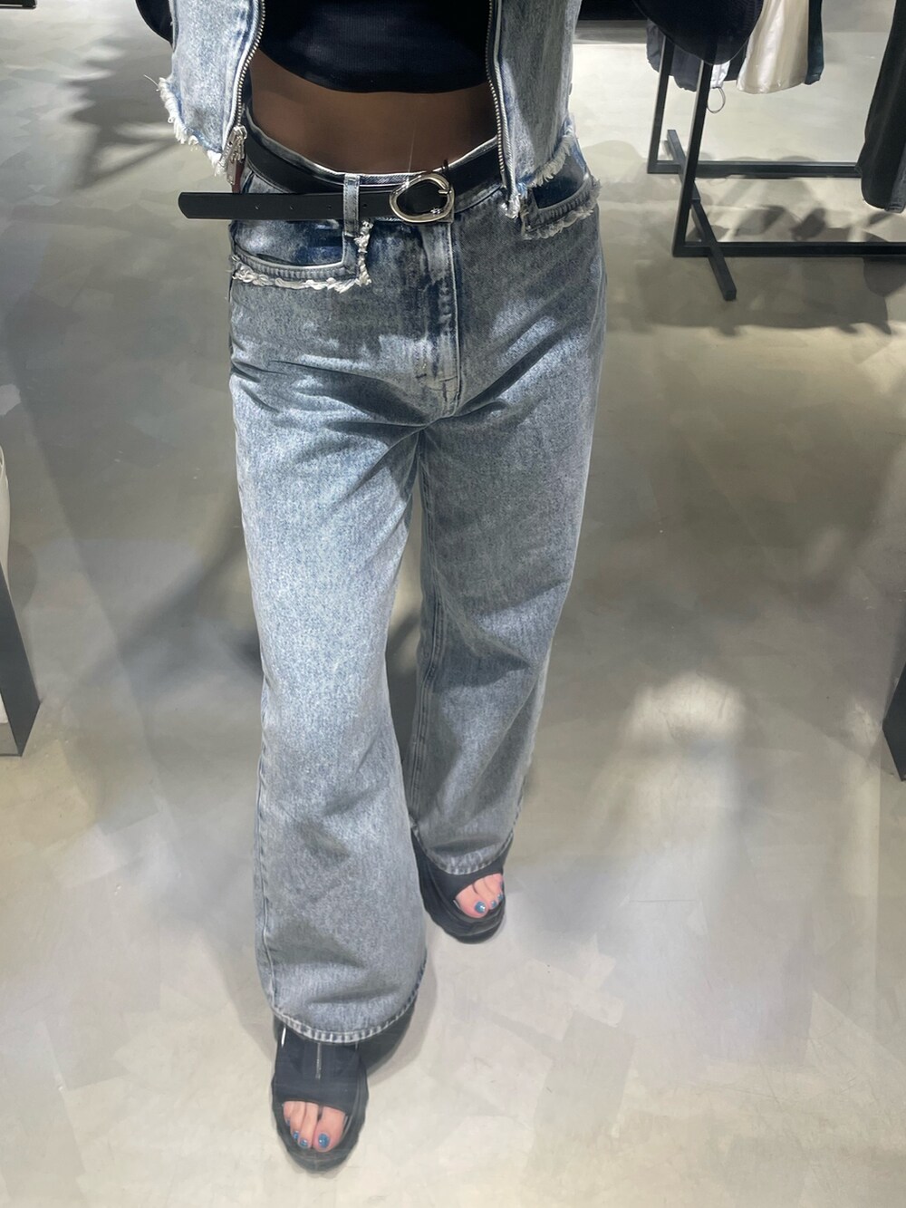 ブラック系のTシャツ/カットソー、ブルー系のベスト、ブルー系のデニムパンツを着用したレディースの春コーディネートの6枚目の写真