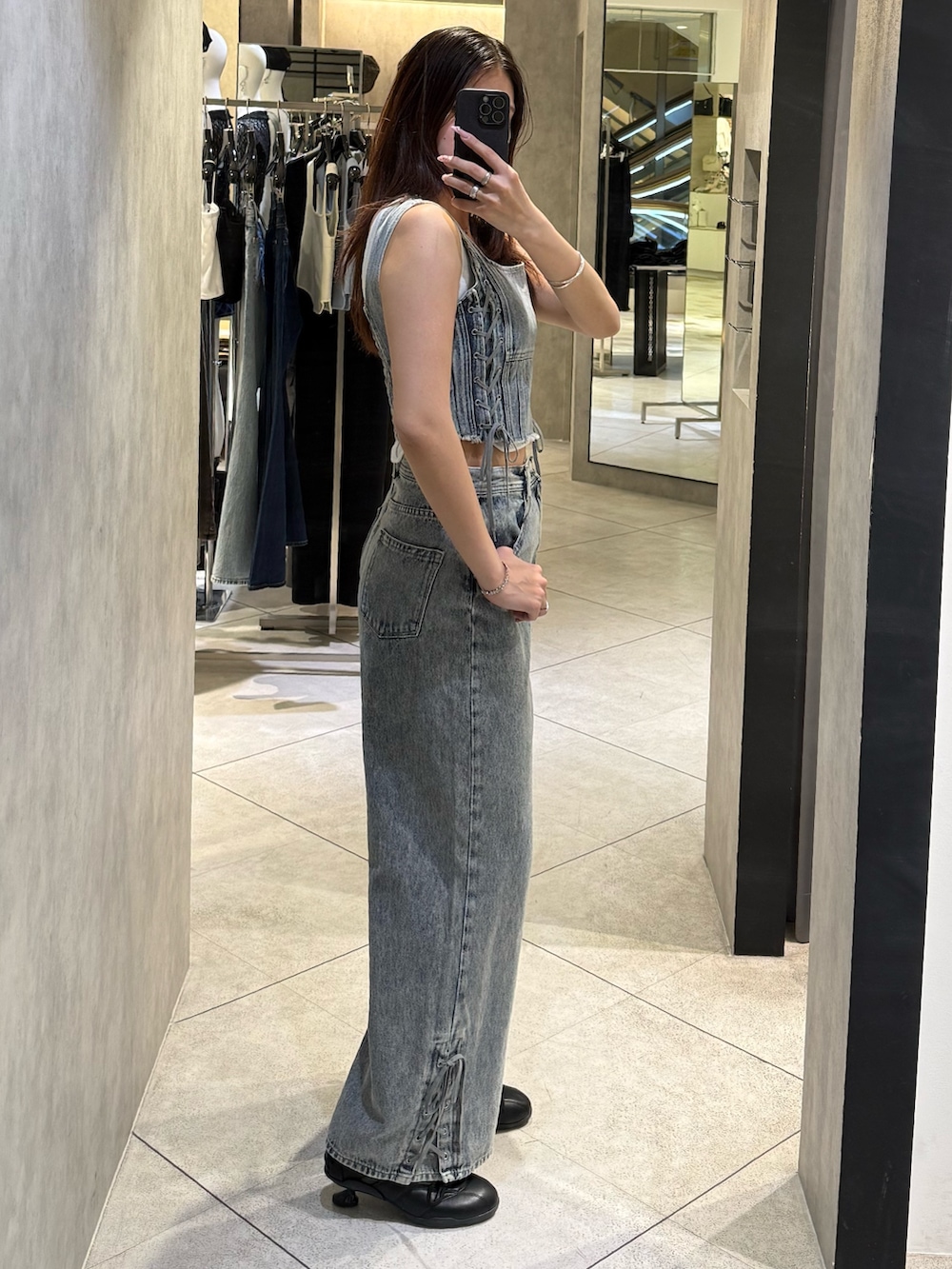 ホワイト系のニット/セーター、ブルー系のタンクトップ、ブルー系のデニムパンツを着用したレディースの春コーディネートの2枚目の写真