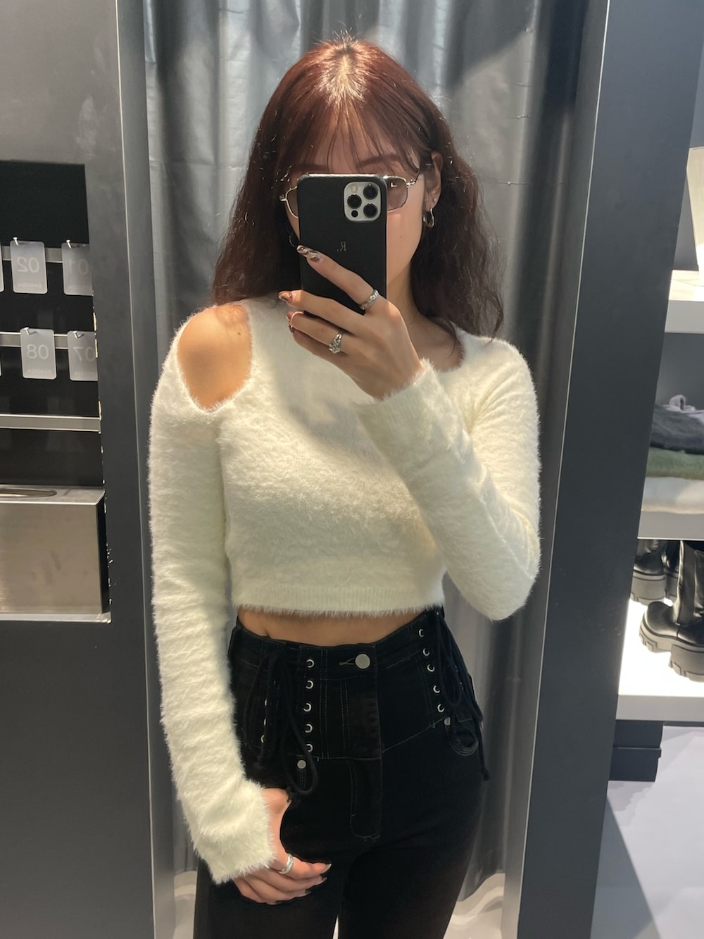 ホワイト系のニット/セーター、ブラウン系のダウンジャケット/コート、ブラック系のデニムパンツを着用したレディースの冬コーディネートの6枚目の写真