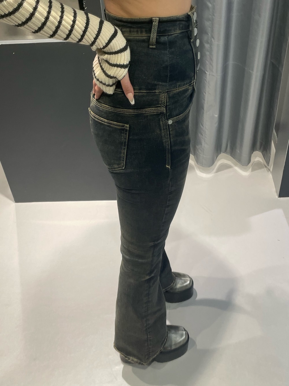 ブラック系のニット/セーター、ベージュ系のブルゾン、ブルー系のデニムパンツを着用したレディースの冬コーディネートの10枚目の写真