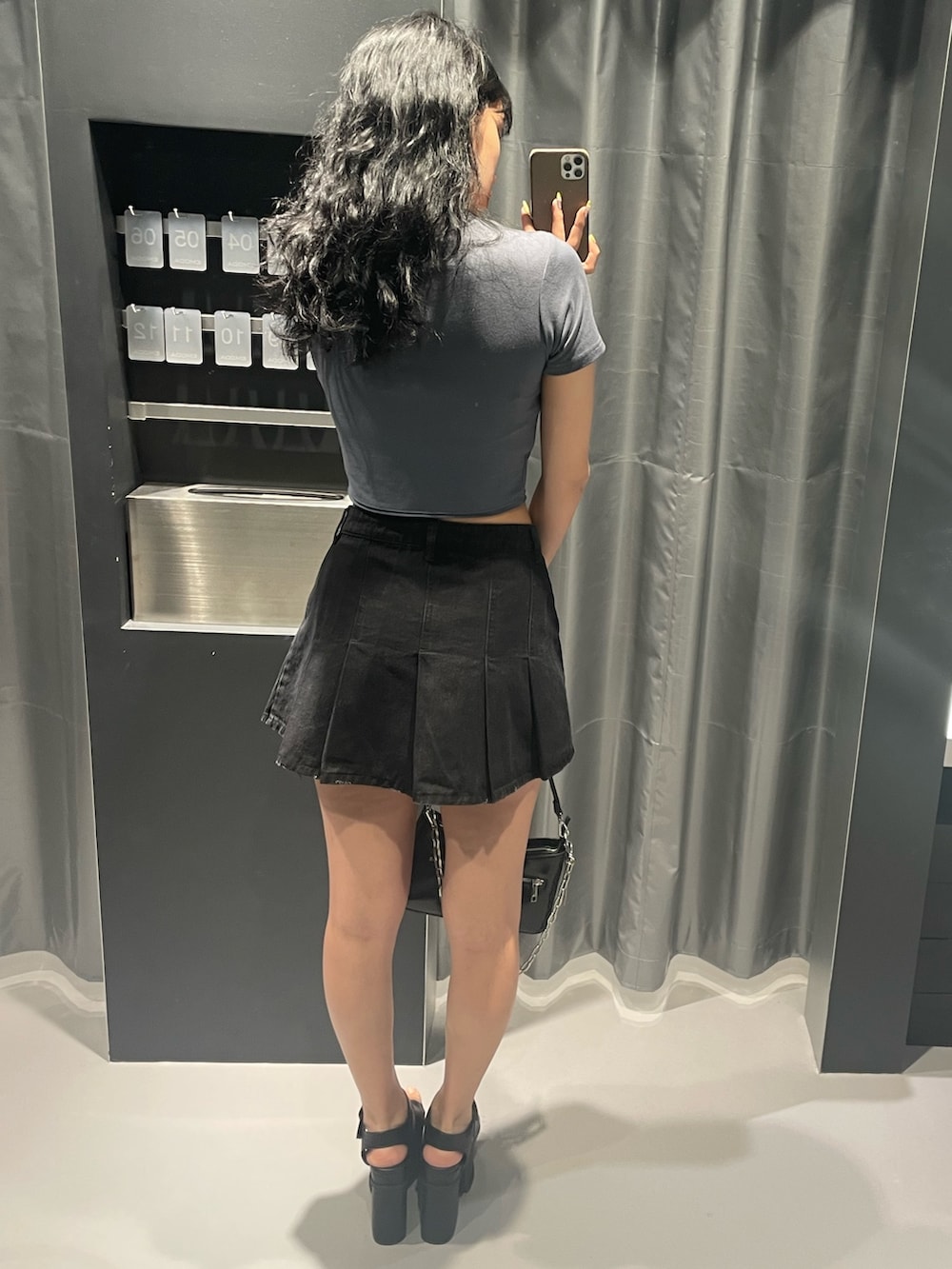 グレー系のTシャツ/カットソー、ブラック系のデニムスカート、ブラック系のショルダーバッグを着用したレディースの春コーディネートの3枚目の写真