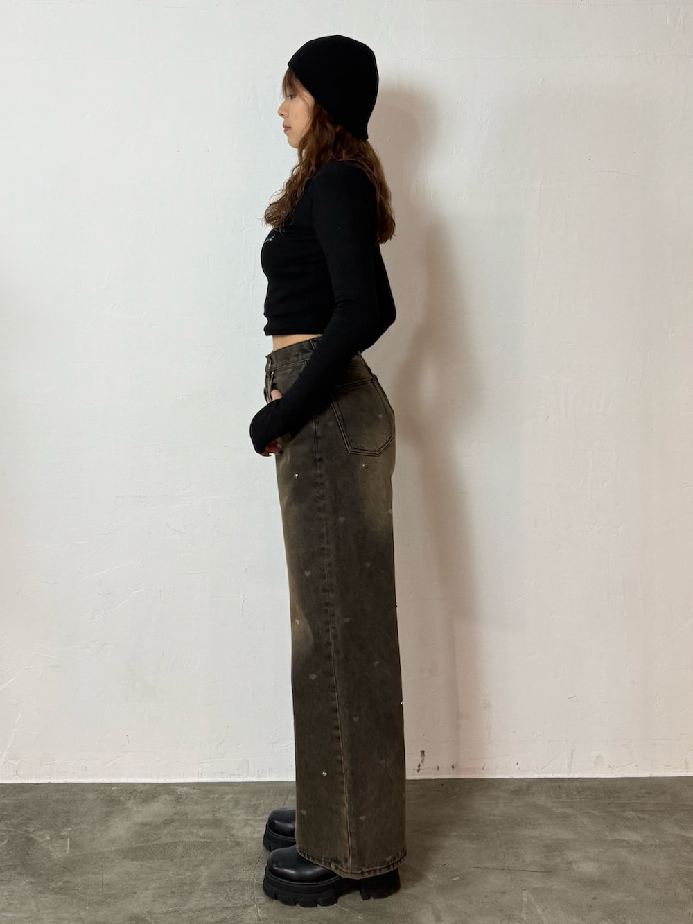 ブラック系のTシャツ/カットソー、ブラウン系のデニムパンツ、ブラック系のブーツを着用したレディースの秋コーディネートの2枚目の写真