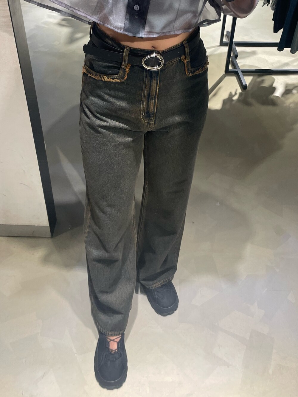 グレー系のニット/セーター、ブルー系のシャツ/ブラウス、ブルー系のデニムパンツを着用したレディースの春コーディネートの6枚目の写真