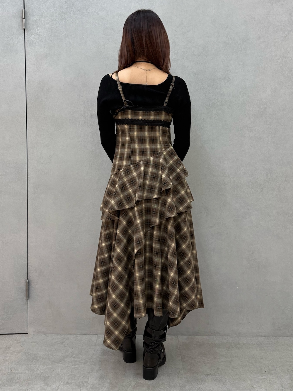 ブラック系のニット/セーター、ベージュ系のワンピース、ブラック系のブーツを着用したレディースの冬コーディネートの3枚目の写真